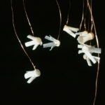 White plastic wall anchors hanging on wires