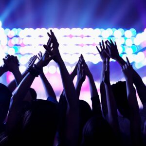 Concert crowd silhouetted against colorful stage lights