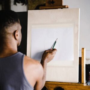 Person sketching on blank paper on easel