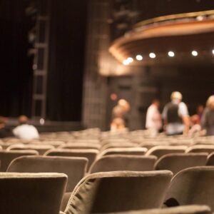Empty theater seats with blurred audience behind