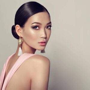Elegant woman in pink dress with tassel earrings